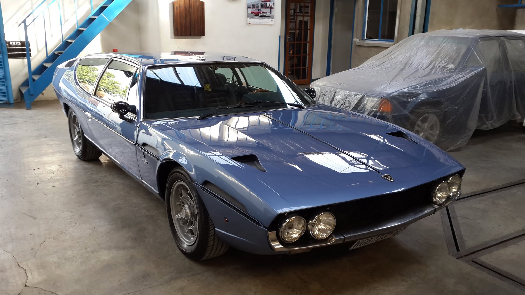 A restored Lamborghini Espada on the floor of the AB Panelbeaters workshop